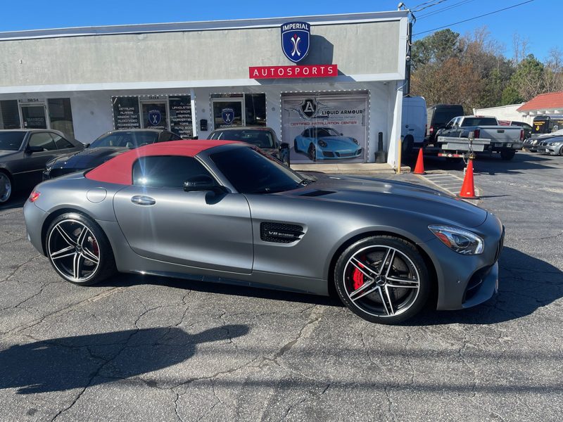 Silver Mercedes-AMG GT Roadster with a red convertible top parked outside Imperial Autosports showroom.