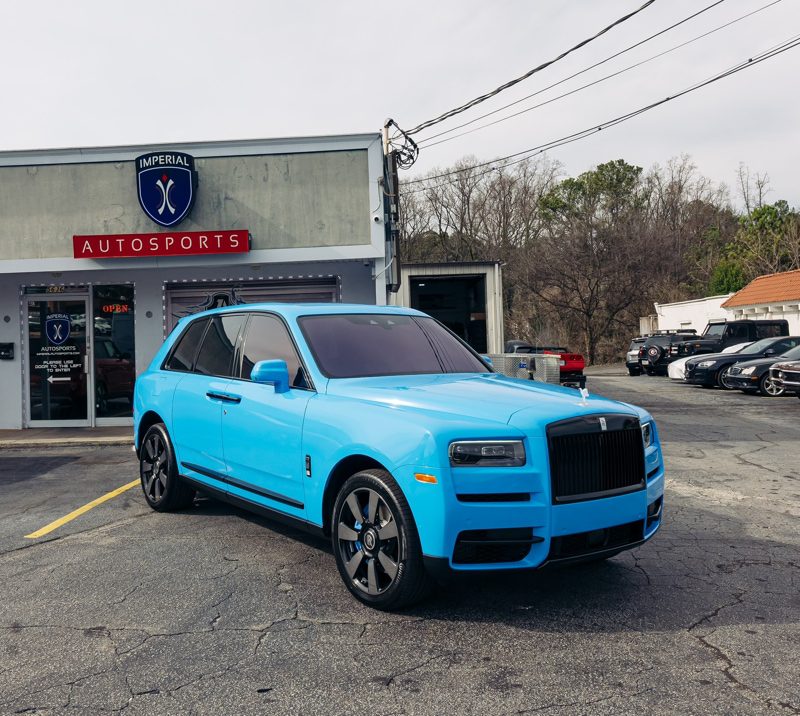 Blue luxury SUV parked outside the Imperial Autosports dealership.